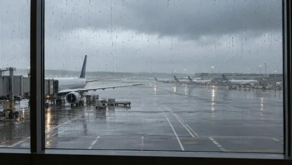Durante uma tempestade costeira, as janelas do terminal com vista para as aeronaves num pátio de aeroporto húmido formam riscos de chuva.