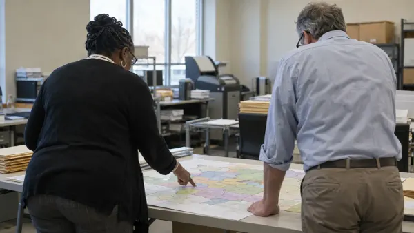 Trabajadores electorales revisan un mapa sin anotaciones de los distritos congresionales en una oficina de un condado de…