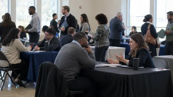 Las personas que buscan empleo conversan con los reclutadores en una feria de empleo comunitaria sin marca, a la luz natural del día