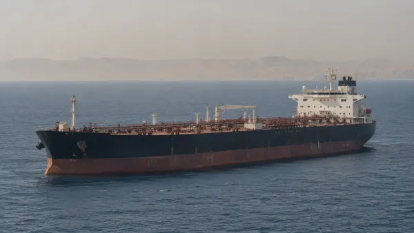 Un buque cisterna de petróleo crudo sin marca se encuentra en alta mar bajo la luz difusa del día, cerca del Estrecho de Ormuz.