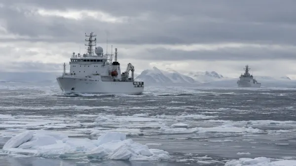 An unmarked white research ship crosses broken Arctic sea ice while a distant cutter monitors from offshore.