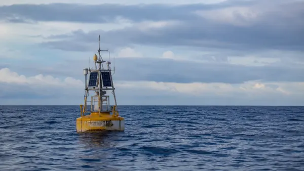 Una boya de monitoreo oceanográfico sin marca que flota en el Pacífico abierto bajo un cielo cubierto de nubes en capas