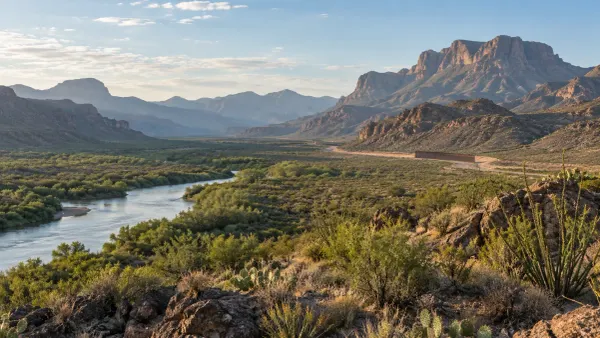 Vista representativa do Rio Grande a serpentear pelo terreno desértico do oeste do Texas, junto a uma barreira rodoviária ao longe