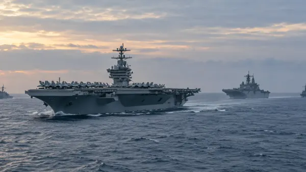 Illustrative view of a modern aircraft carrier and escort ships underway at dawn