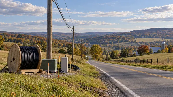 Isang kalsada sa kanayunan ng Pennsylvania na may mga poste ng kuryente at kagamitang fiber-optic na inihanda para sa pagpapalawak ng broadband.
