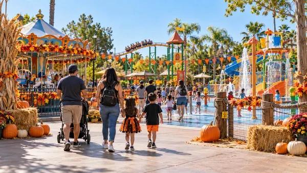 Famílias a passear por um colorido parque de diversões e aquático do sul da Califórnia, decorado para o outono