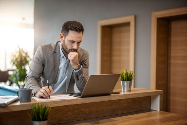 Businessman working on a laptop at a wooden desk
