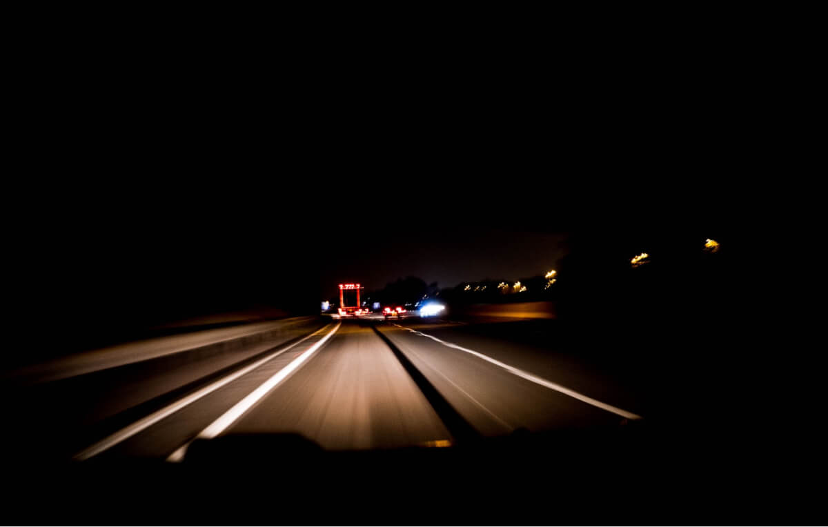 Driving a car in the night with headlights on 