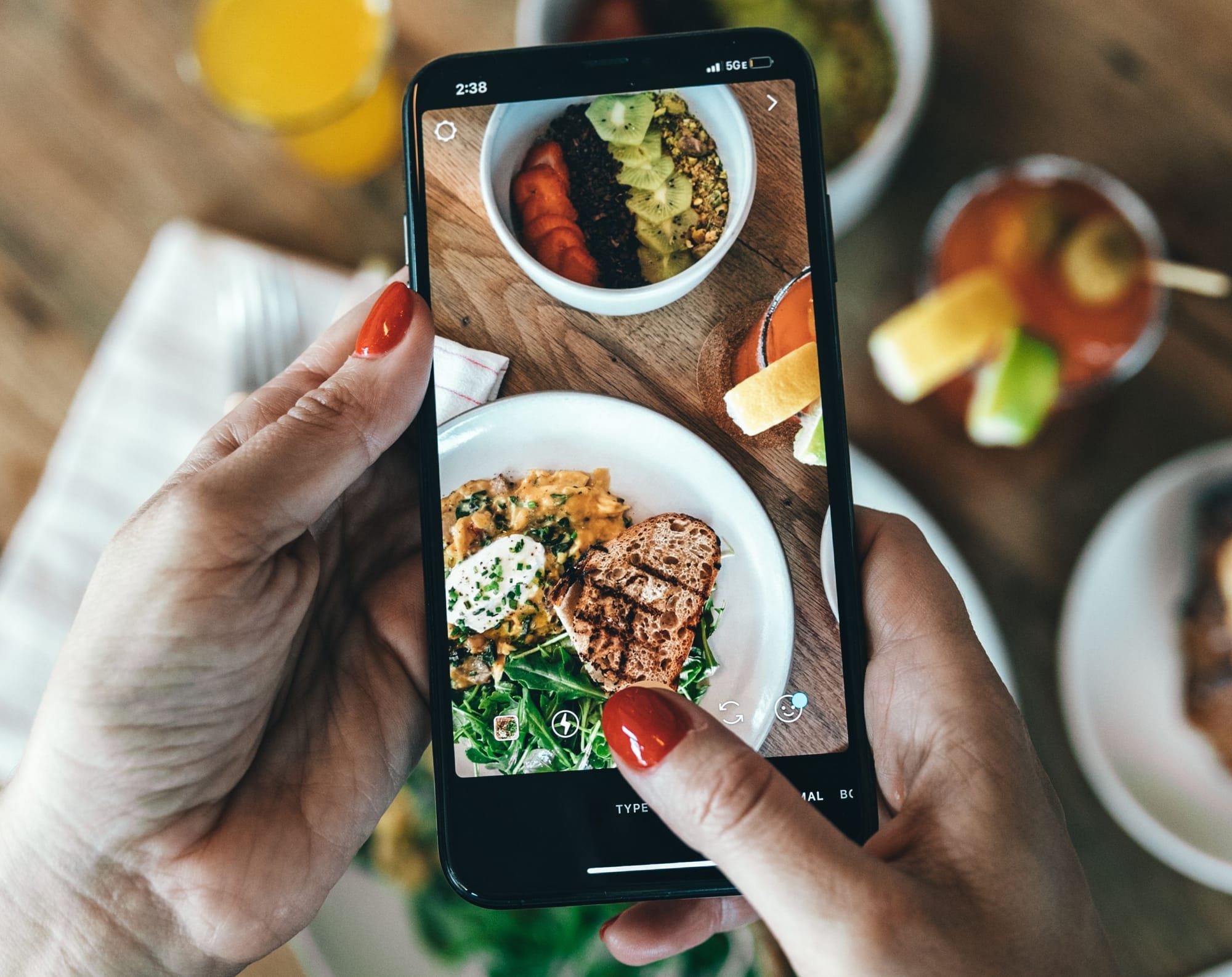 Restaurant loyalty and customer content: a diner photographing a table of dishes on a phone camera screen