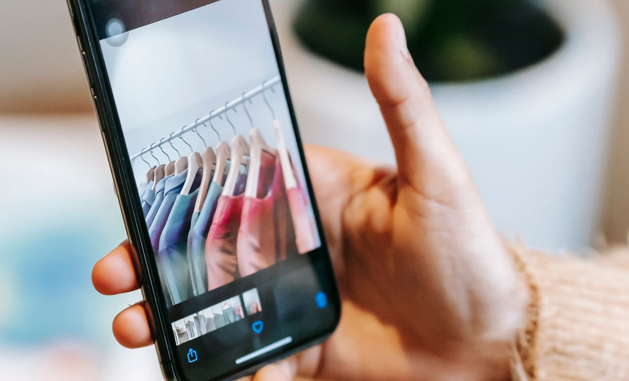Collecting UGC for a new Shopify store: a customer photographing a rail of clothes on a phone