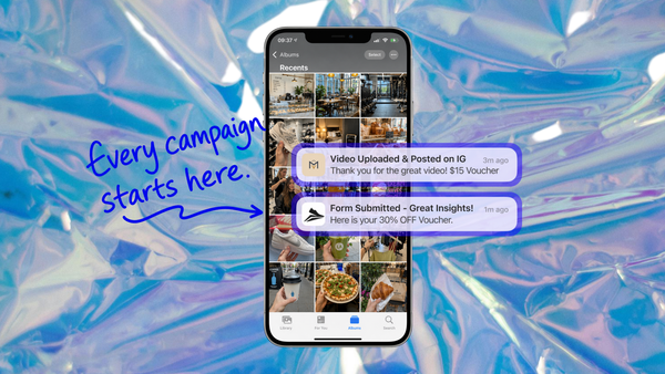 Wallet pass push notifications on a smartphone campaign feed, confirming a video upload and a discount voucher