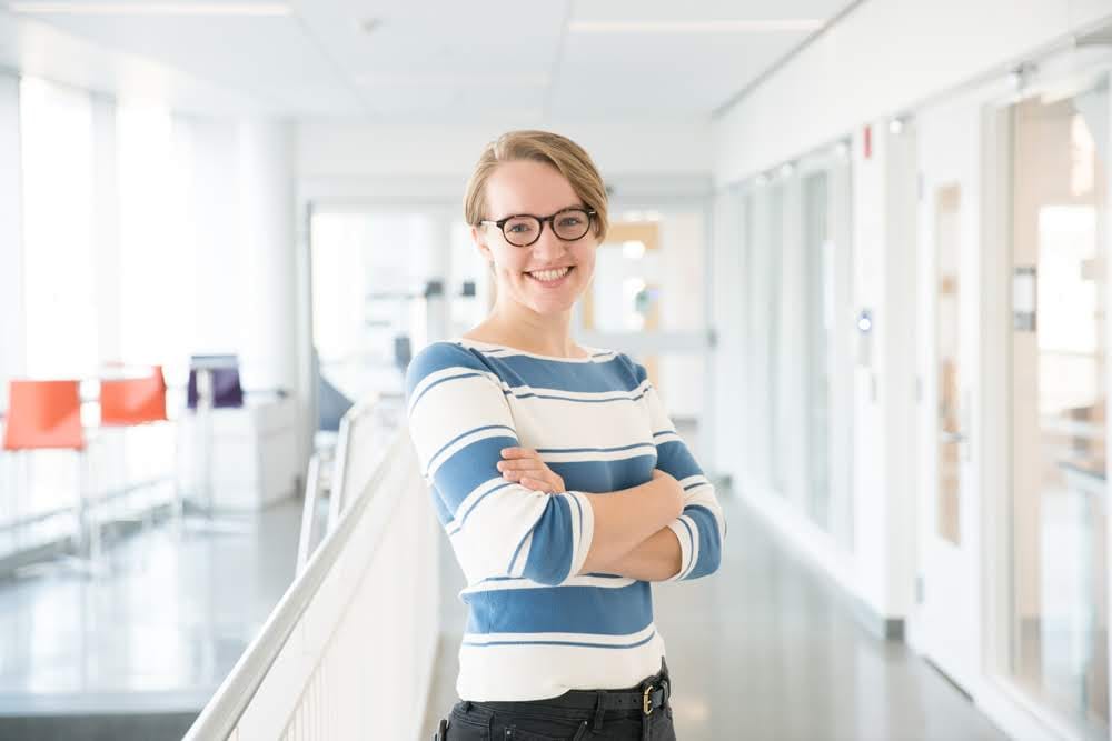 Maggie Oates smiles, a white femme with short hair. 