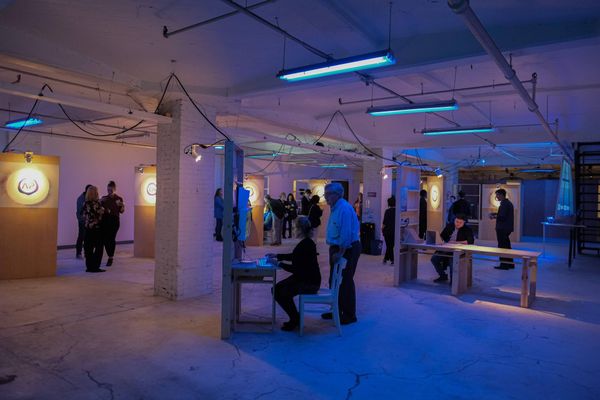 A large group of people mill about playing weird art games at a performance of "Project Amelia."