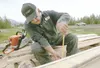 ROBERT DeBERRY/Frontiersman Bob Thom takes some measurements
before beginning his cuts on a cottonwood log. Thom has begun
cutting the logs into 2-by-8 and 2-by-6 planks of wood with a chain
