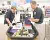 ROBERT DeBERRY/Frontiersman Walmart associate Alison Halpin,
left, and co-manager Aaron King straighten school supplies in the
Foundations for the Future donation bin set up at the Wasilla
Wa