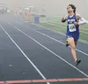 Palmer High senior Fischer Adams crosses the finish line first at Saturday’s state high school cross country championships. Adams dominated the damp, fog-shrouded event from the start, winnin