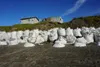 Houses seen on Aug. 2, 2022, teeter on the edge of an Utqiagvik bluff that is being rapidly eroded by permafrost thaw. The house on the right has been abandoned. At the base of the bluff are 