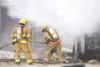 ROBERT DeBERRY/Frontiersman Two Central Mat-Su firefighters
water down hot spots Monday as smoke continues to billow from a
house on Hay Drive in Palmer.