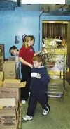 From left, Salvation Army volunteers Jonna May, 13, Natalie May,
12, and Scott May, 10, work to complete a food box recently. The
Mays attend home school and volunteered to help. Photo by Cas
