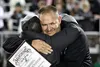 Colony High School principal Kristy Johnston hugs band director Dr. Jamin Burton after presenting Burton with a plaque commemorating Burton's 20 years as the director of the school's marching