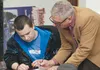 Donn Liston helps Jace Paul Coulombe with a math lesson. Coulombe is one of about 30 students signed up for classes at Nine Star Educational and Employment Services’ new office in Wasilla. HE