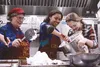 Good Shepherd Lutheran Church kitchen manager Alice Renfro looks on as Wasilla High School students Toni Nance, center, and Sara Schindler scoop homemade marshmallow creme onto a pan of graha