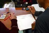 Elections workers double-check the results of Alaska's Aug. 16, 2022 primary election during a meeting of the state review board on Tuesday, Aug. 30, 2022 at the Alaska Division of Elections 