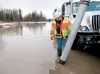 Wasilla city employee Jess Griffiths watches as water is sucked up near the corner of Peck Street and Bogard Road Monday morning. Griffiths said the drainage system is having trouble keeping 