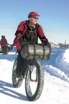 It’s important to be prepared for the elements when venturing
out on a fat-tire bike in winter, especially for people who plan to
stay overnight or longer. Here, Jeff Oatley stows equipment u