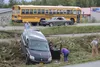 Members of the Frontiersman staff and passersby call Alaska State Troopers and check passengers in the wake of a wreck involving a First Student School Bus and a dark gray minivan Thursday af