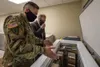 Maj. Juan Guzman, chief of the Armed Services Blood Bank Center-Pacific Northwest, shows Assistant Secretary of Defense for Health Affairs Thomas McCaffery where the center stores the convale