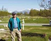 Wayne Bouwens stands among the headstones in the Palmer Pioneer
Cemetery. Photo by RINDI WHITE/Frontiersman.