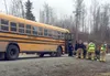 Paramedics attend to a school bus driver who suffered a medical emergency while dropping off students on Friday, March 25. The man was alert and talking with paramedics when he was loaded int