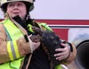 Central Mat-Su Fire Department paramedic supervisor Ginny Jackson carries two reptiles after the animals were removed from a burning home on Plymouth Circle in Wasilla on Friday, April 8, 201
