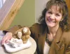 Photo courtesy Barbara Adams Darcy Logan shows off the
one-of-a-kind nativity that Aaron Barrett carved from whalebone and
ivory.