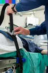 U.S. Air Force Maj. Nick Lents, a 673d Surgical Operations Squadron nurse, tightens down a safety restraint at the hospital on Joint Base Elmendorf-Richardson, Alaska, Aug. 5, 2021. Lents wor