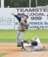 Alaska Road Warriors shortstop Damon Hammer makes a throw to first base while Chugiak’s Deven Ferris tries to break up a double play during Chugiak’s 10-1 win over the Road Warriors during th