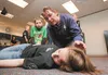 Darlene Johnson and her son Brendan, 10, help volunteer Ashley Gibbs, who is playing an injured all-terrain vehicle rider, during the fifth annual Emergency Expo Saturday at Mat-Su College. R