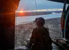 Sgt. Rosalind Stromberg, a crew chief from 1st Battalion, 207th Aviation Regiment, Alaska Army National Guard, looks over the Kuskokwim River from the door of a UH-60L Black Hawk helicopter d