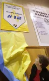 SAM HARREL/Fairbanks Daily News-Miner Jeannie Hebert-Truax
reveals a banner honoring her during a ceremony retiring her No. 12
jersey Wednesday in Boileau Hall at Monroe Catholic School in
Fa