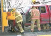 ROBERT DeBERRY/Frontiersman Memebers from Central Mat-Su Fire
Department work on extricating a man from a small truck after
getting in a head-on collision with a school bus Thursday afternoon