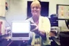 ROBERT DeBERRY/Frontiersman Penny Saunderson, interim technical
director at Alaska Sleep Clinic in Wasilla, holds a seasonal
affective disorder lamp. Saunderson sits at her desk with the SAD
