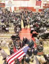 ROBERT DeBERRY/Frontiersman The flag-draped coffin of former
state legislator and Mat-Su Borough Mayor Curtis Delbert Menard is
wheeled out of the Wasilla High School gymnasium Saturday after