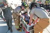 Firefighter airman Lester and airman Roberts from the 673rd Civil Engineer Squadron at Joint Base Elmendorf-Richardson lower Eric Edwards, 6, into his custom built fire truck Friday at the JB