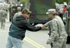 Mike Cooper shakes hands and says thank you to a member of the
military marching in the Wasilla fourth of July parade Sunday
afternoon. (ROBERT DeBERRY/Frontiersman)