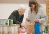 Duffie Mallonee, 92, gets help from volunteer Marilyn White picking up the fixings for a Thanksgiving dinner at the Valley Thanksgiving Blessing Saturday at Wasilla Bible Church. According to