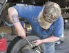 Johnson Tire employee Roy Barnett puts a weight on a tire
Thursday afternoon. (ROBERT DeBERRY/Frontiersman)