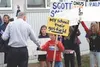 Gov. Frank Murkowski shakes the hand of a young protester
Wednesday before proceeding into the Palmer Moose Lodge to address
the Greater Palmer Chamber of Commerce. Below, a dog joined in the