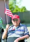Two-time Wasilla mayor Harold Newcomb waves a U.S. flag at a 2010 Memorial Day ceremony. A longtime community activist and volunteer, Newcomb died Monday at age 83. ROBERT DeBERRY/Frontiersma