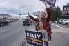 Kelly Tshibaka waves at passing motorists in Midtown Anchorage on Aug. 16, 2022. The former U.S. Senate candidate, now head of a nonprofit opposing ranked choice voting, is the subject of a n